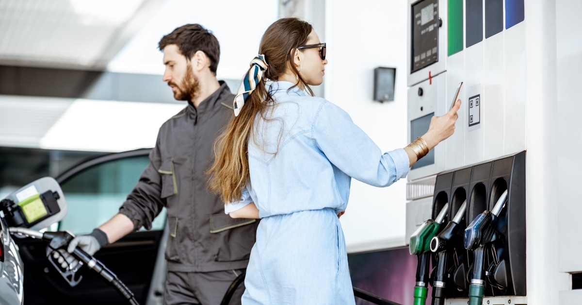woman paying with phone for gasoline
