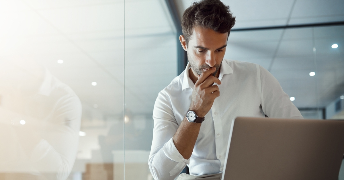 businessman looking thoughtful while working on his laptop
