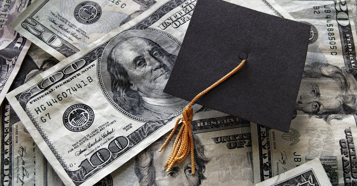 graduation cap on united states dollars scattered around
