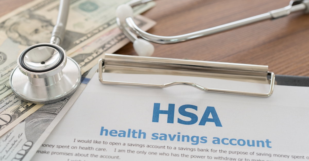 health savings account paper on clipboard with stethoscope and money on wooden table