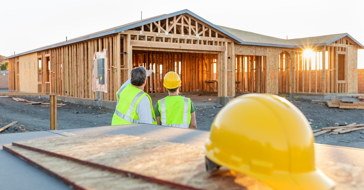 male and female construction workers at new home site