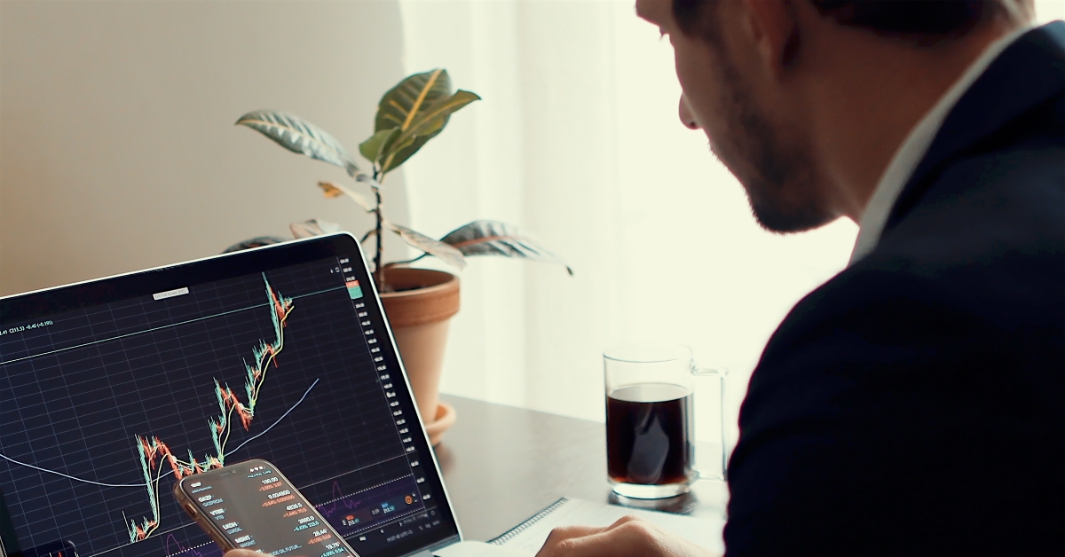 crypto trader using phone and laptop