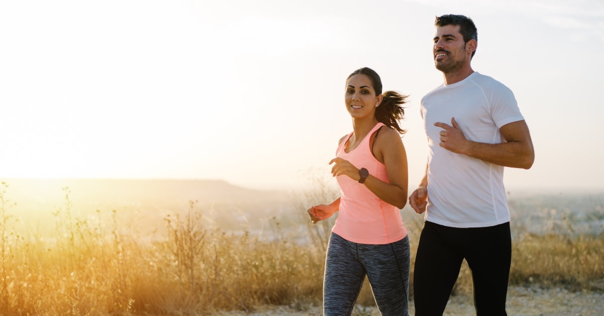 happy couple running while wearing fitness suits