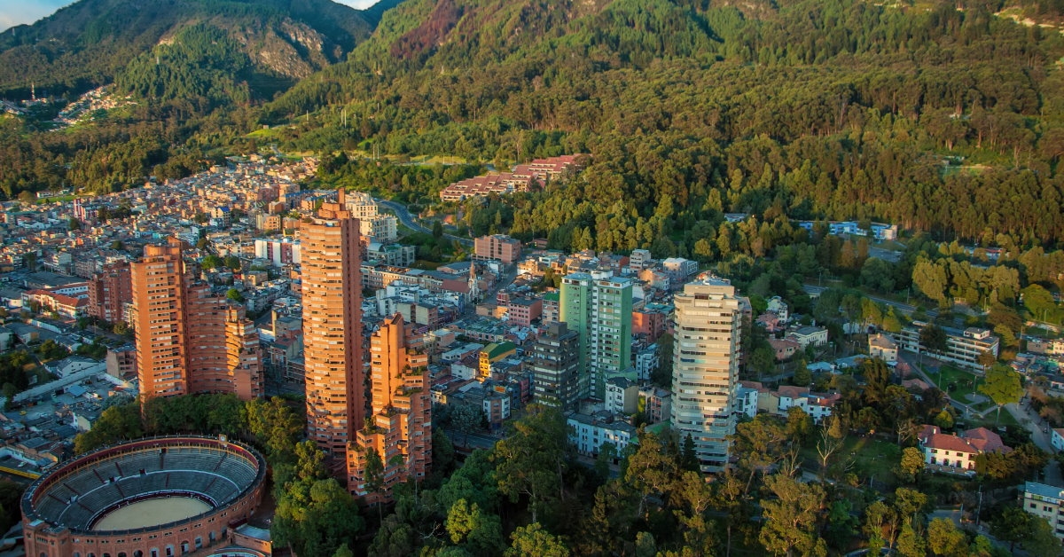 bogota and andes mountains full of greenery in front of tall buildings and houses