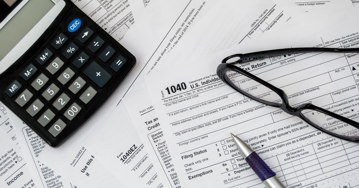 pen glasses and calculator on the tax form