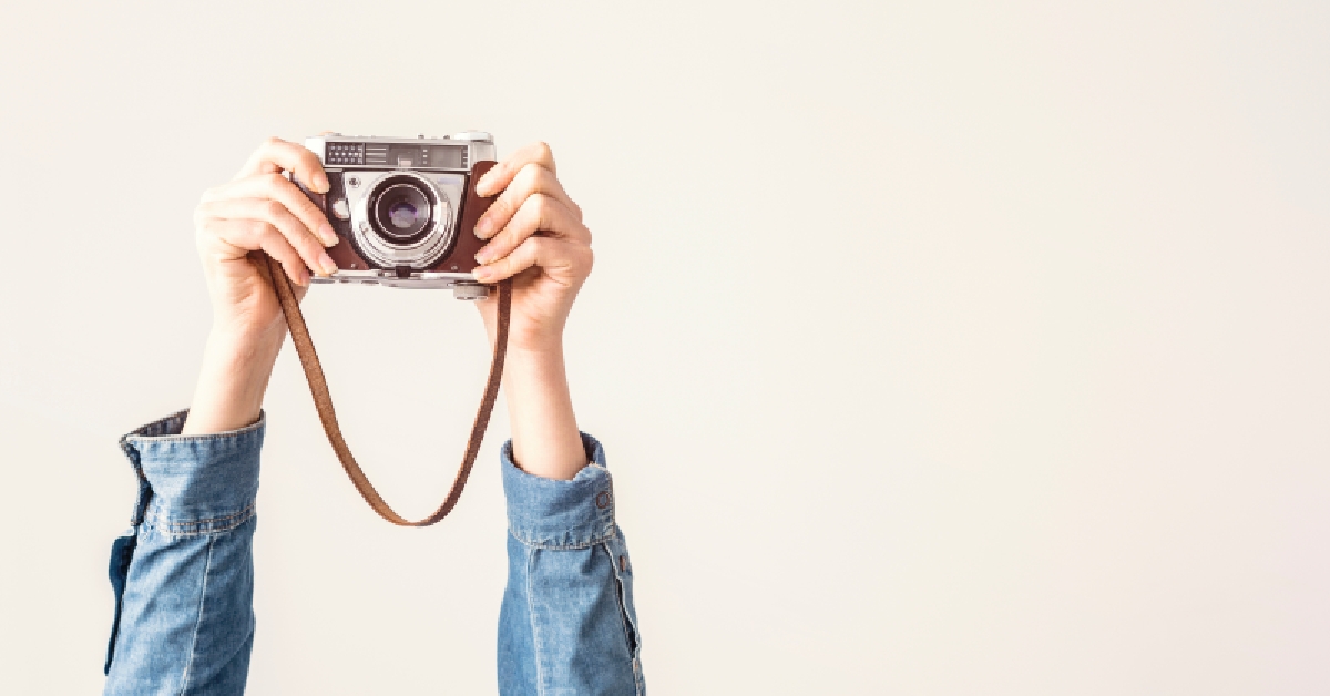 arms up holding vintage camera