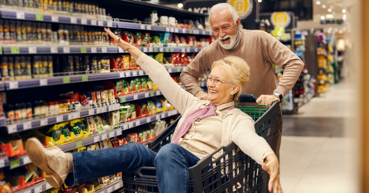 funny old couple is driving in shopping cart