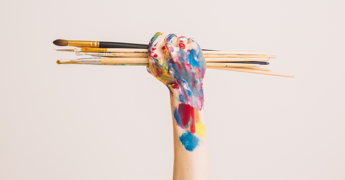 woman's artist's fist in paints with brushes