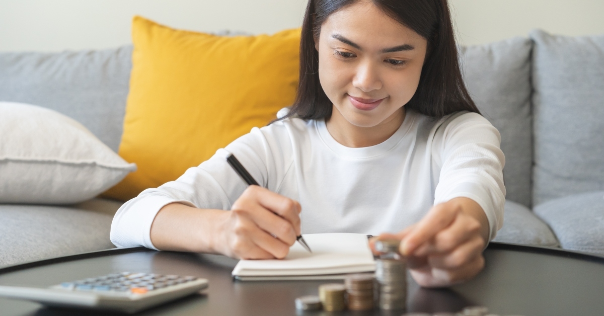 girl putting stack of coins on table