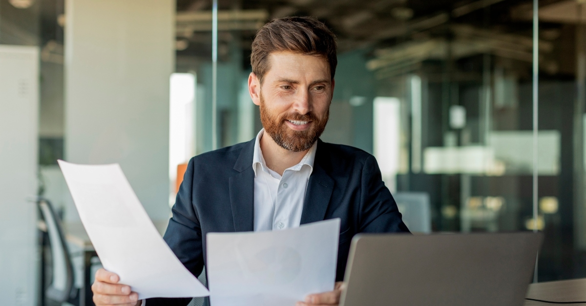 male entrepreneur working with laptop and documents