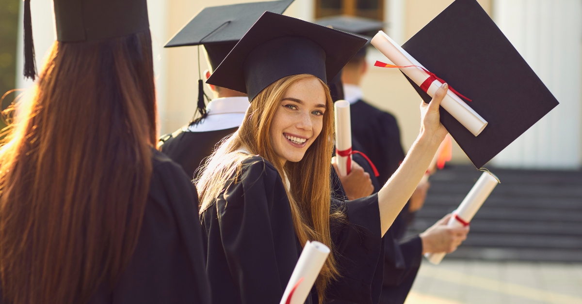 smiling college graduate standing with diploma