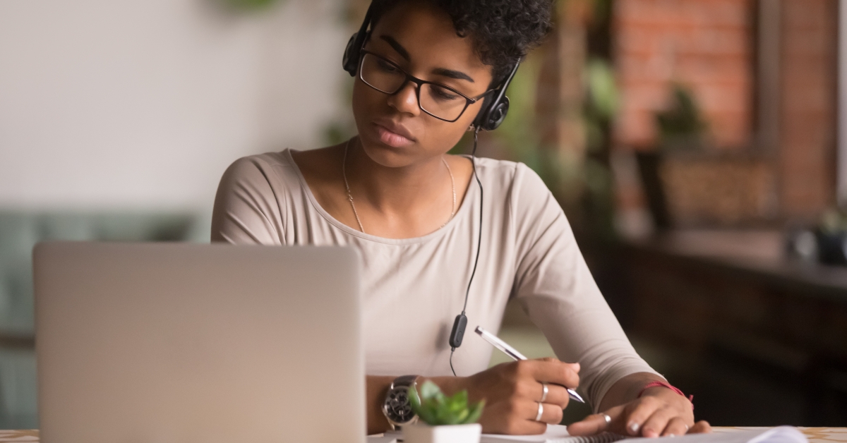 woman wearing headphones watching webinar