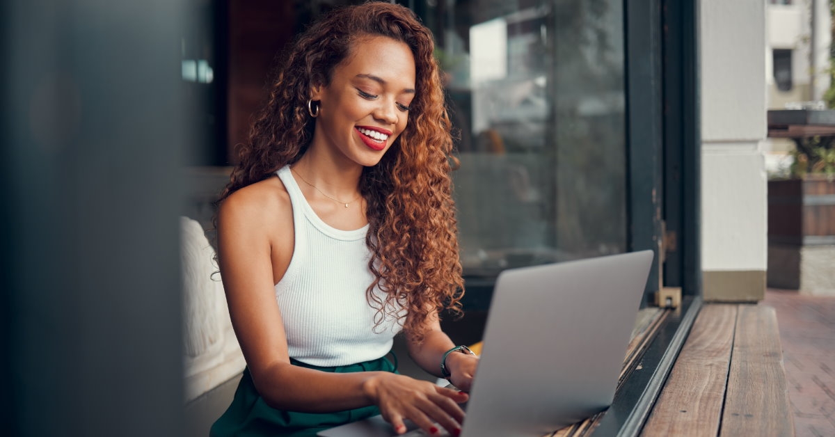 happy woman working remotely from a cafe 