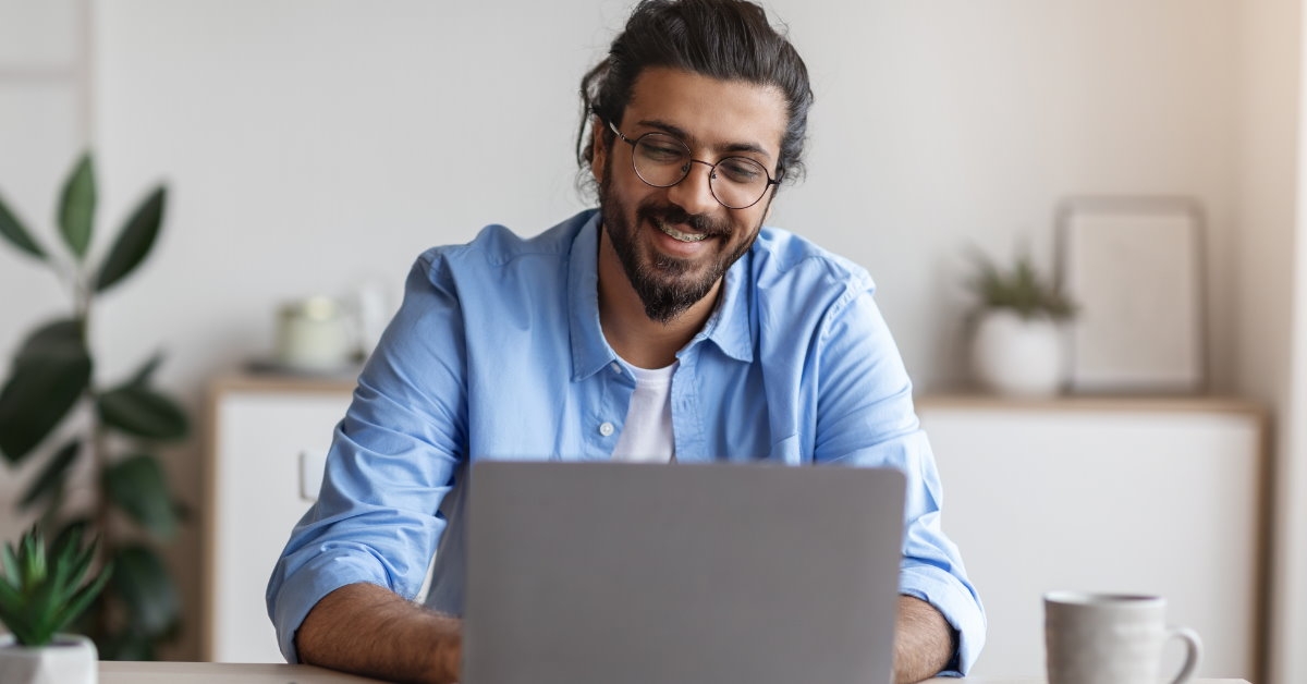 happy male freelancer working on laptop