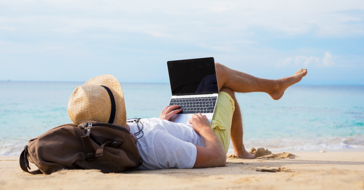relaxed man with laptop on the beach