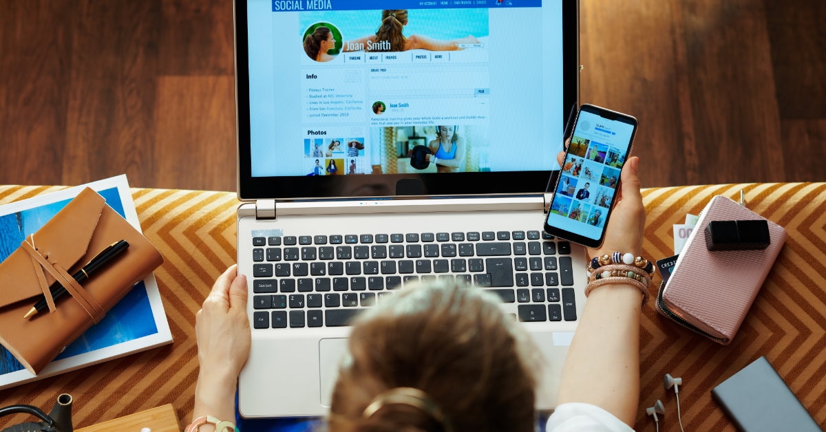 woman using laptop and smartphone to check her social media profile