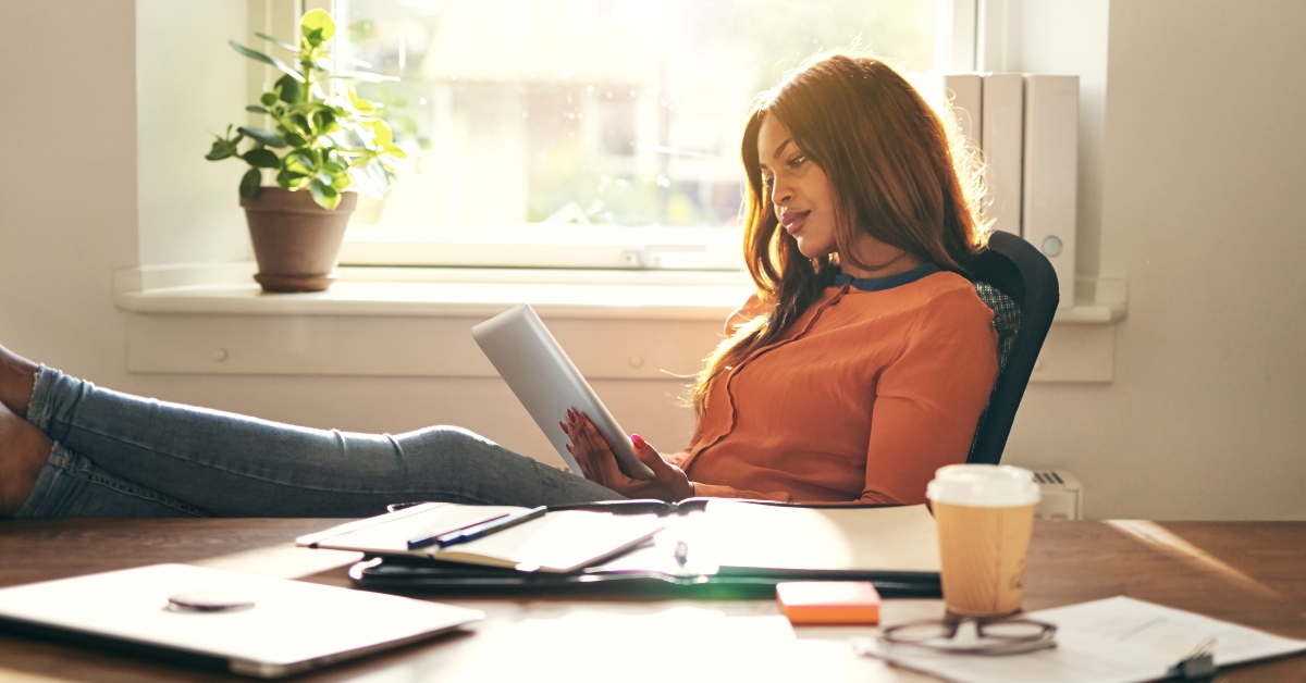 woman leaning back in her office chair working online 