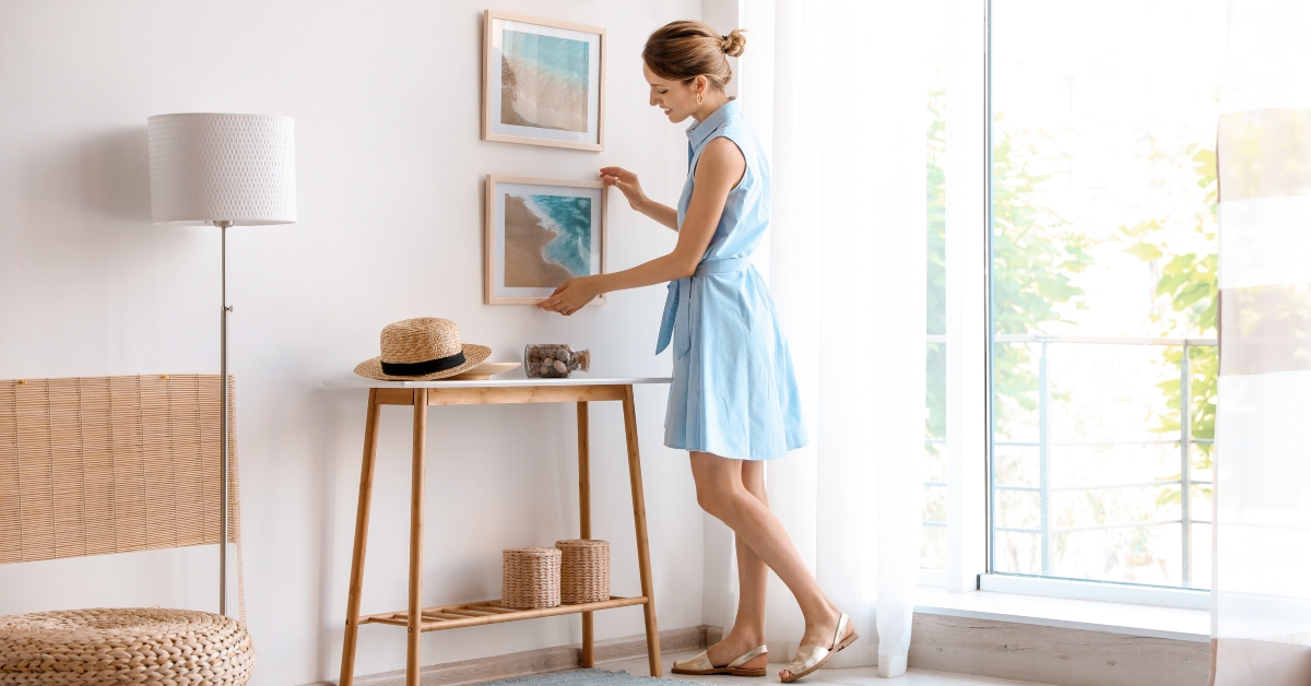 designer decorating white wall with pictures