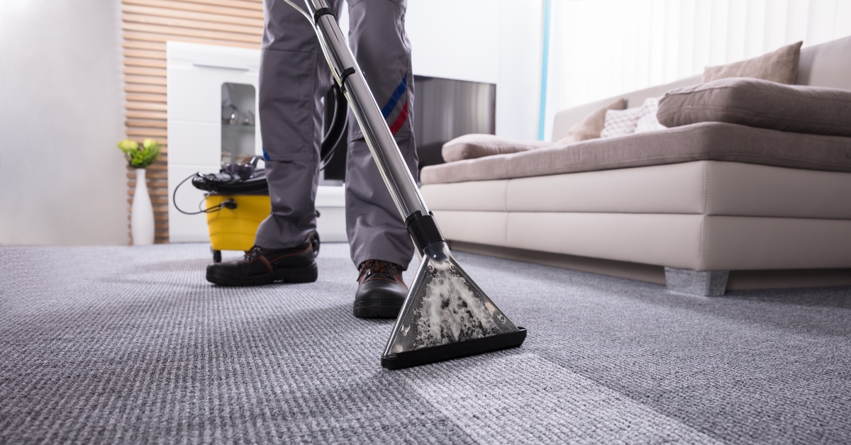 person cleaning carpet with vacuum cleaner