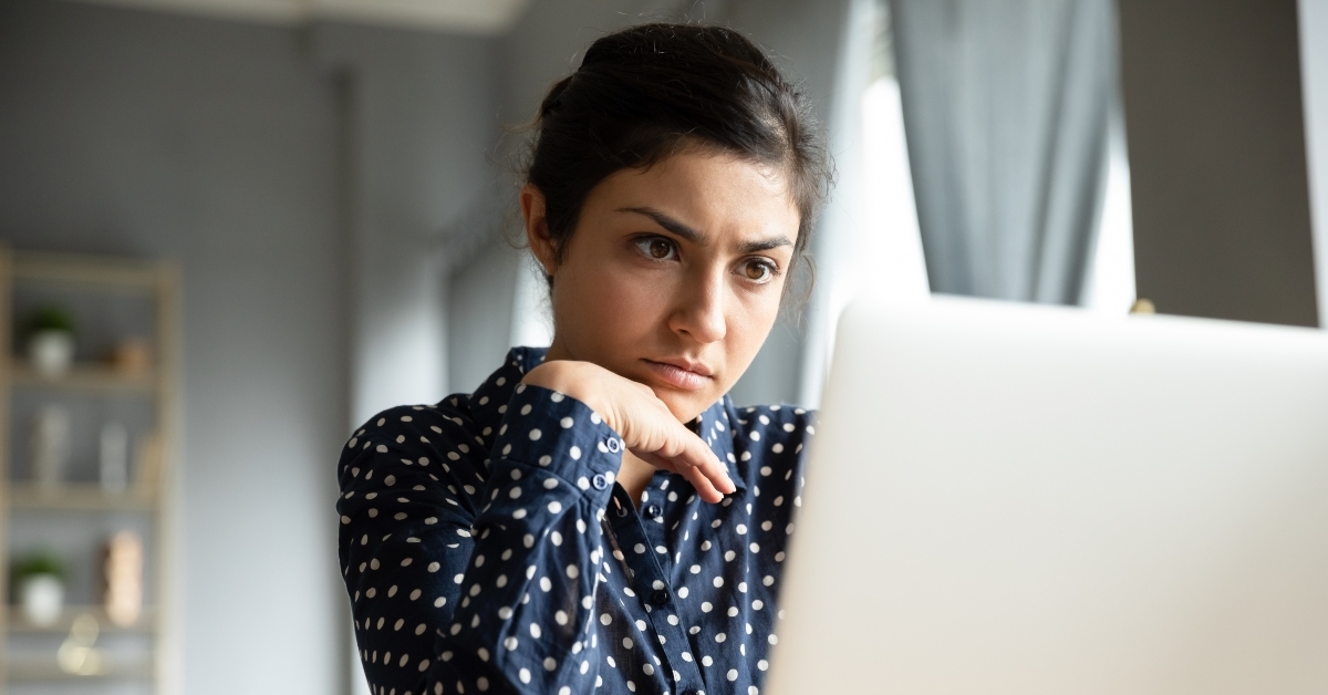 businesswoman sitting at desk looking at laptop