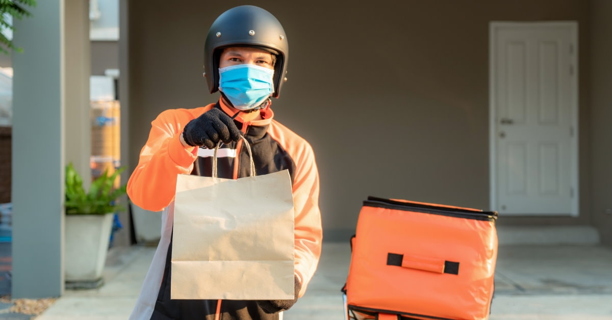 delivery man wearing protective gear holding parcel