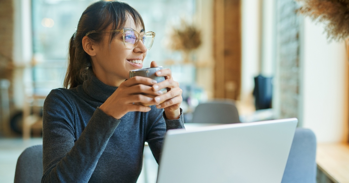 woman enjoying coffee while working in cafe