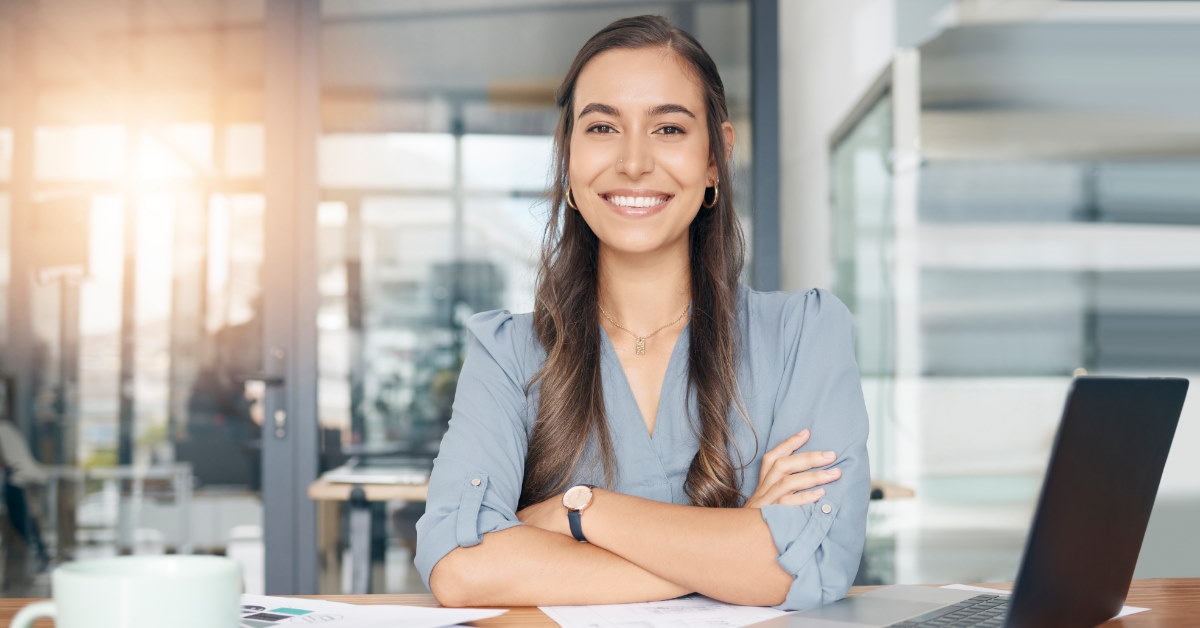 happy business woman at workplace with laptop and papers on table