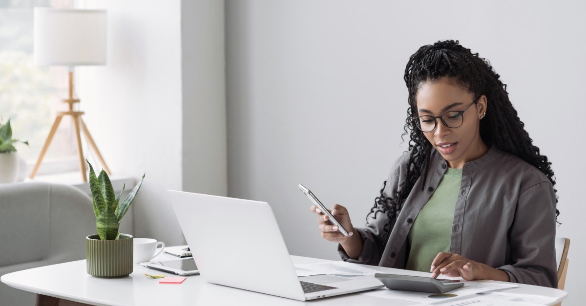 woman accountant in office using laptop and calculator to audit