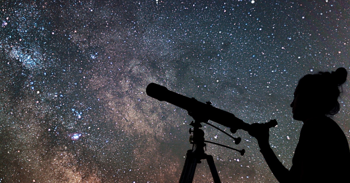 woman using professional telescope for stargazing