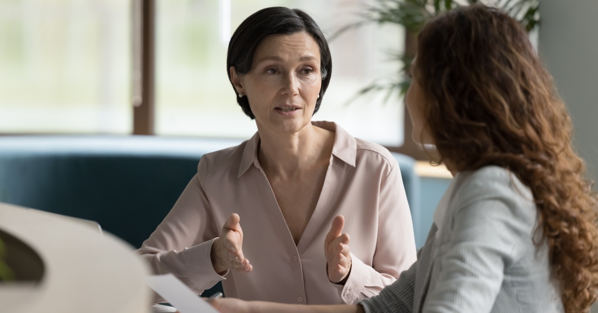 business professional woman talking to younger female colleague