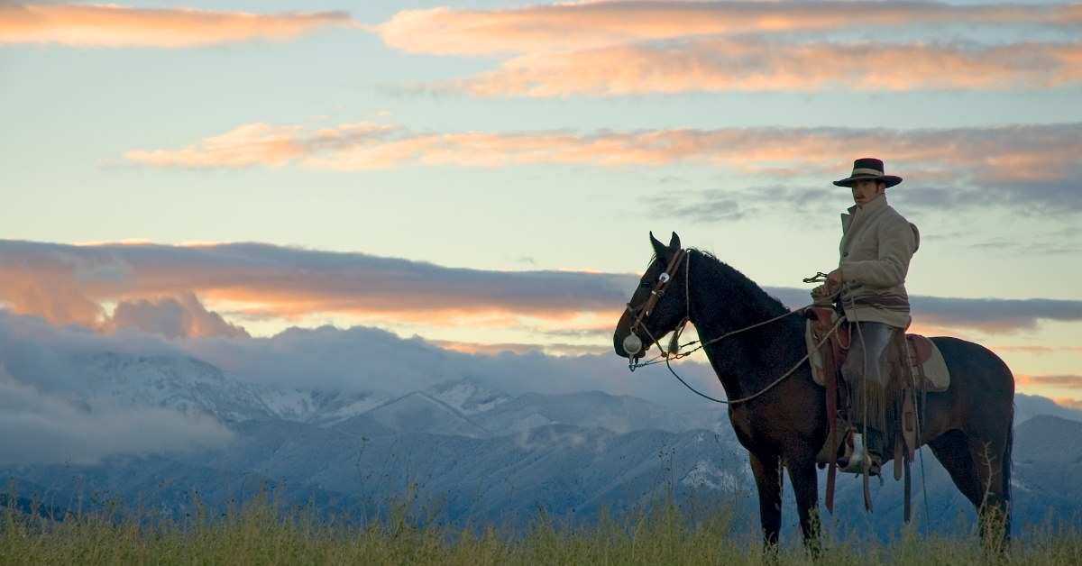 male cowboy riding horse at Montana ridge