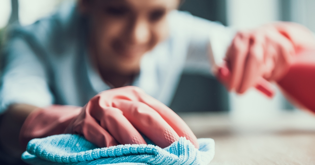 young smiling woman in gloves cleaning house 