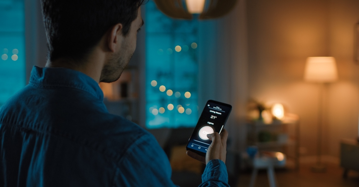 man is holding smartphone with active smart home