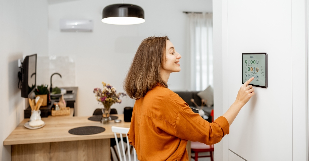 young woman controlling home with a digital touch screen panel