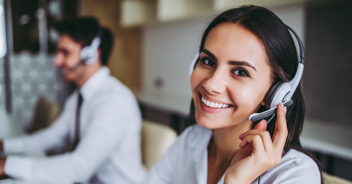 happy female employee at work wearing headsets