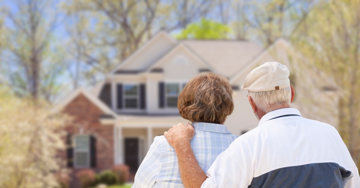 senior couple sitting at front house after retirement
