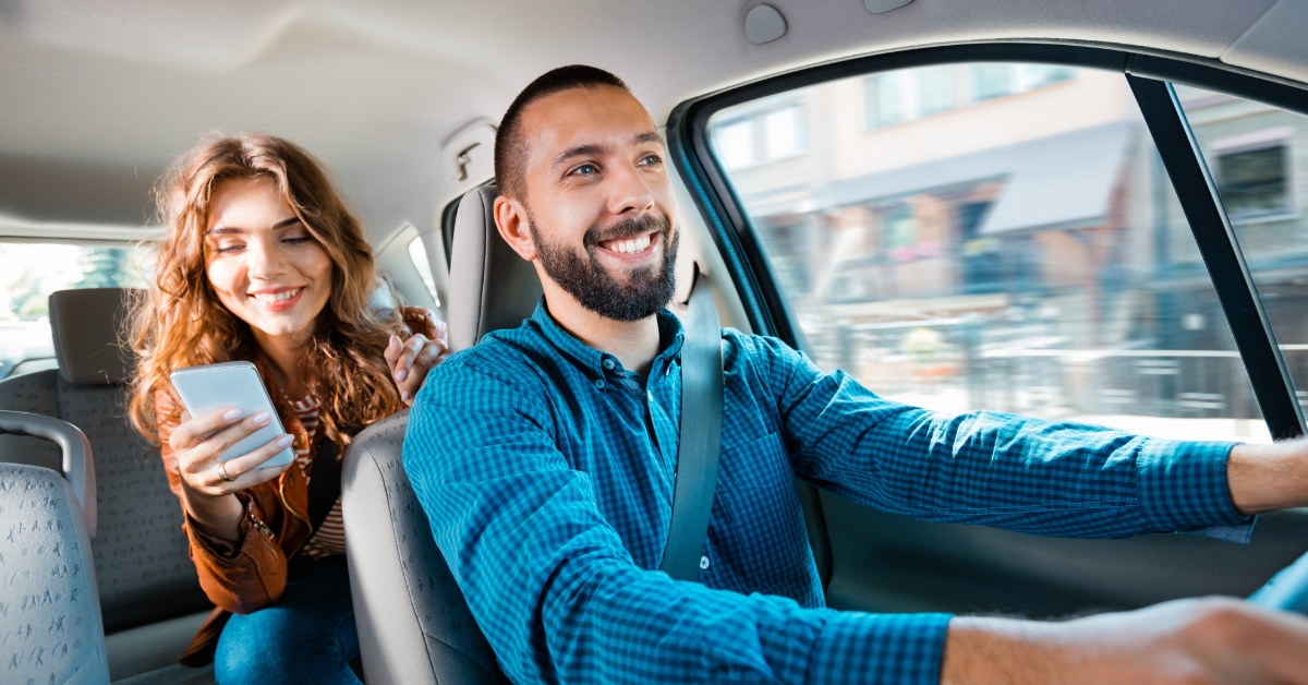 uber driver smiling while driving passenger to destination 