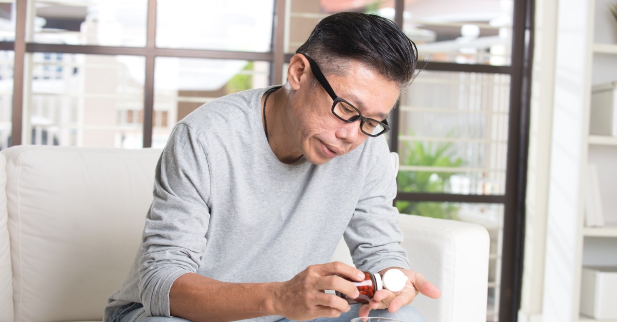 asian man taking pills at home 