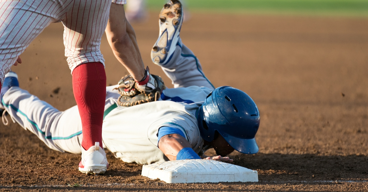 baseball player hitting and sliding