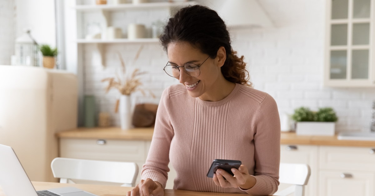 young woman using calculator to sort bills