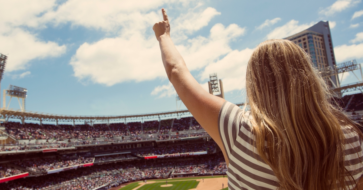 woman standing and cheering at a baseball game