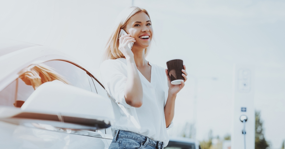 girl talks the phone on tesla car charge station 