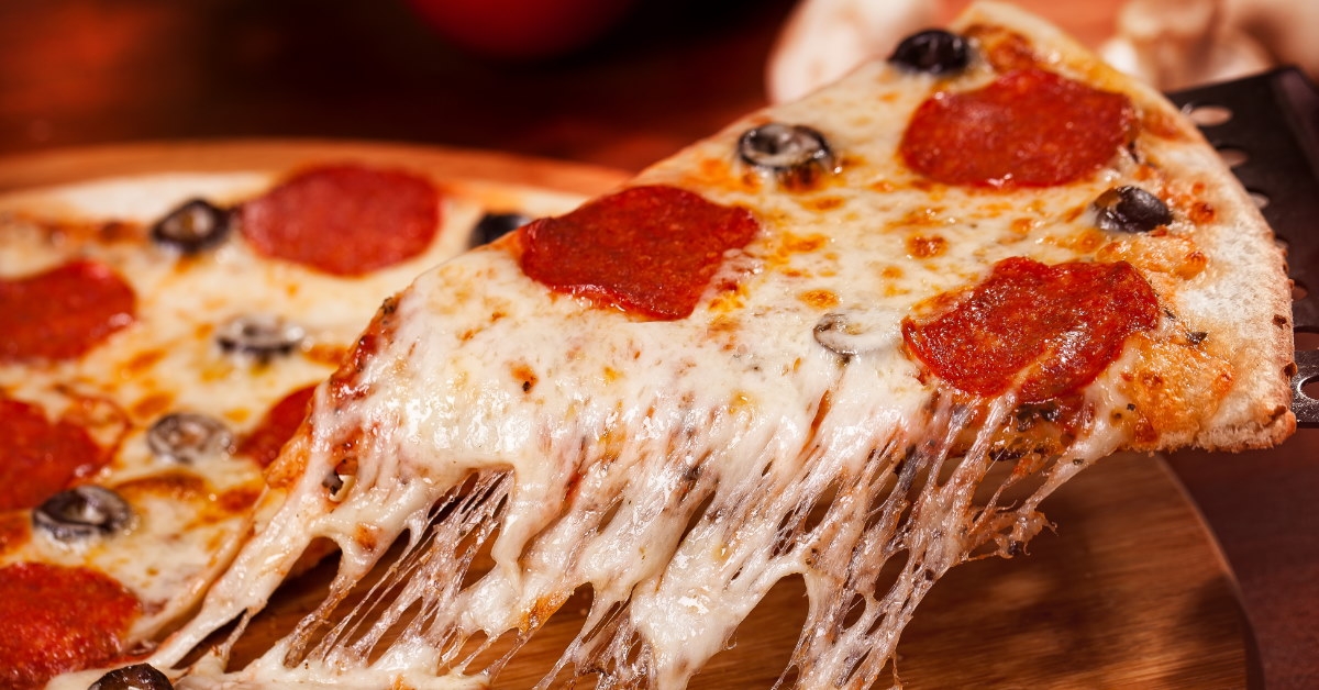 slice of pizza with melted cheese, olives, and pepperoni 