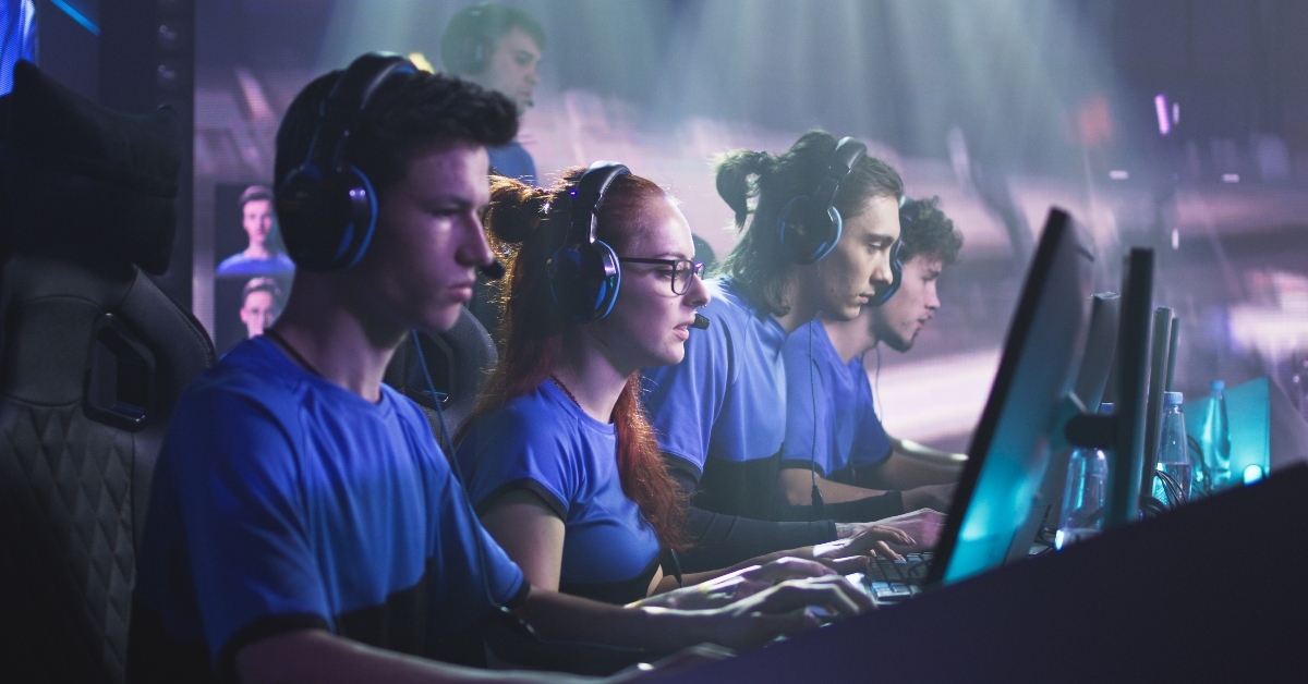 professional gamers with coach playing video game