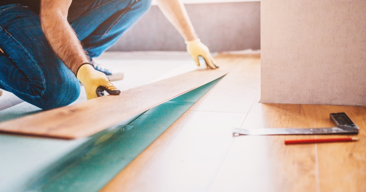 man at home laying laminate flooring - finishing