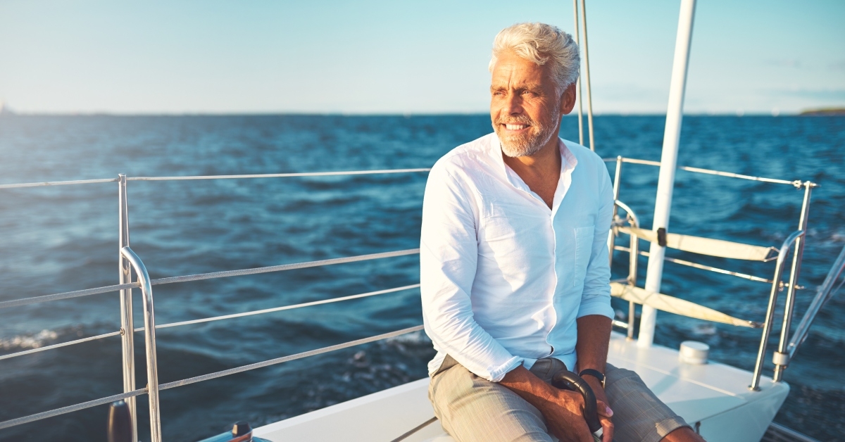 smiling mature man sailing his yacht on a sunny day