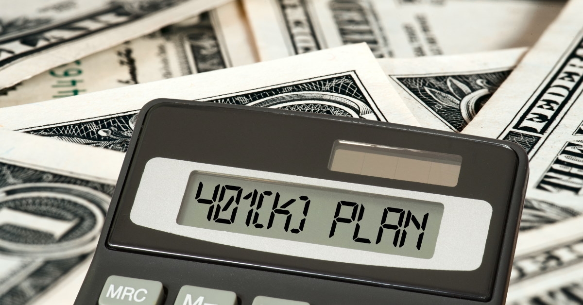 calculator screen displaying 401k plan placed over dollar bills