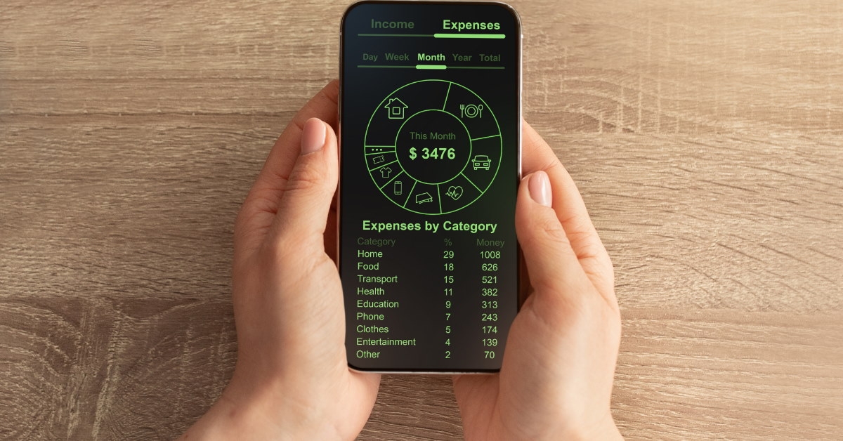 man holding smartphone with finance application on screen reviewing monthly budget