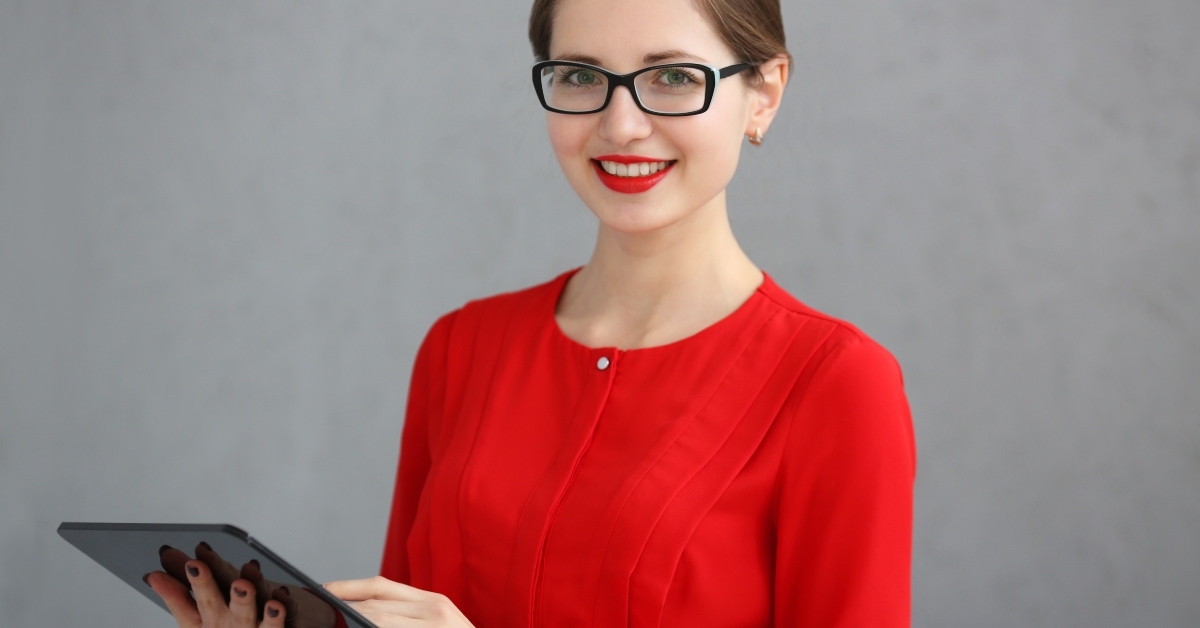 businesswoman in a red shirt and glasses holding a tablet