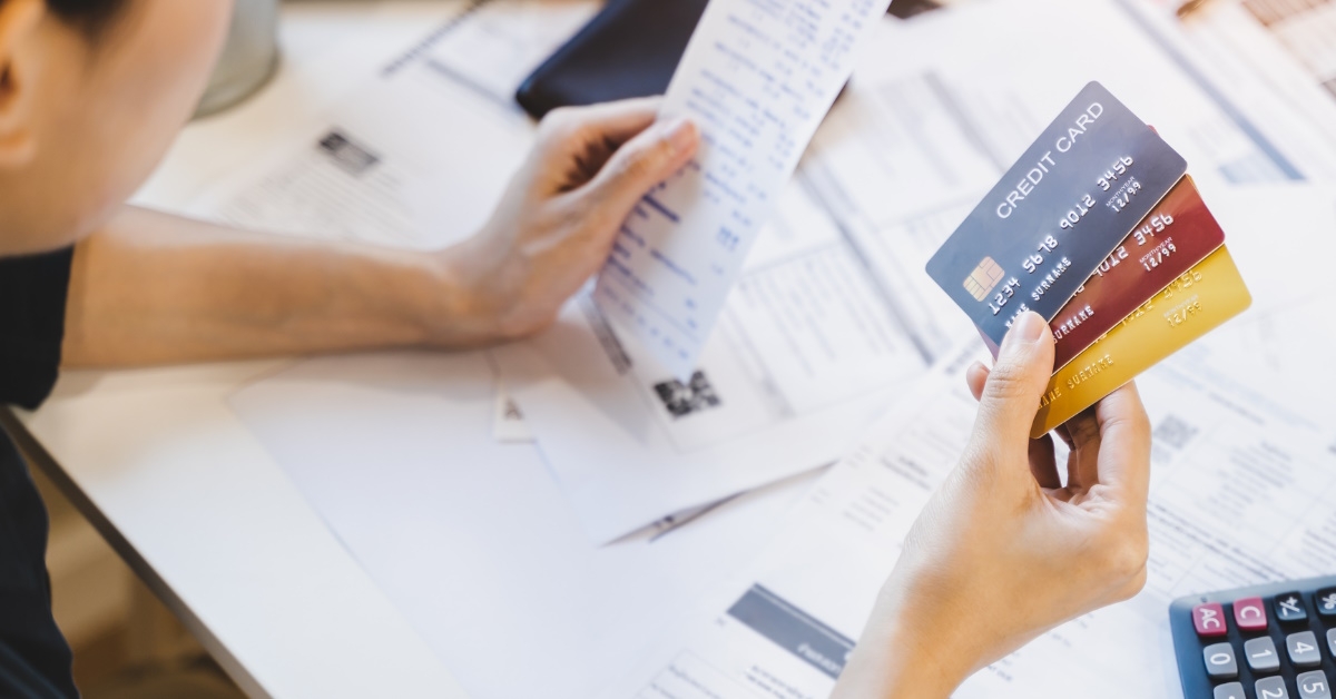 woman sitting at table reviewing long receipt while cards